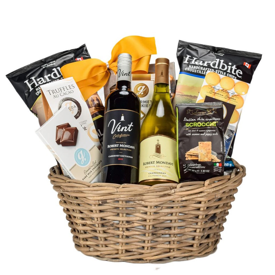 Cabernet And Chardonnay WIne With Chips, Cookies, Chocolate, Pretzels, Crackers In An Oval Rattan Basket With A Gold Bow