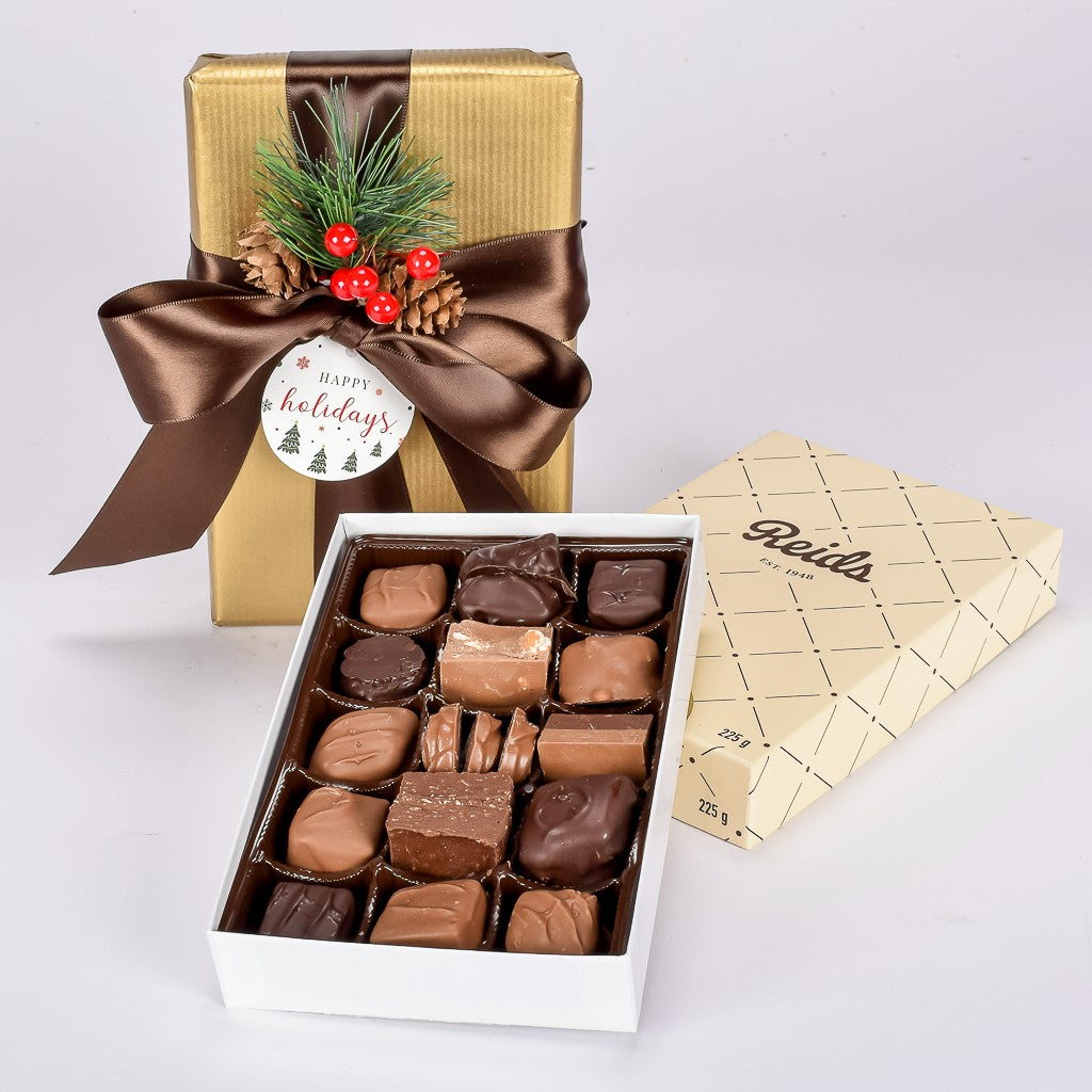 Box of Assorted Milk, Dark, And White Chocolate Wrapped In Gold Paper and Tied With a Silk Bow