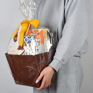 Gourmet Gift Basket Wrapped In Cellophane And Gold Bow